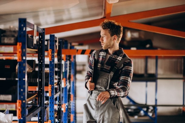 Warehouse employee lifting auto parts inventory in a retail store